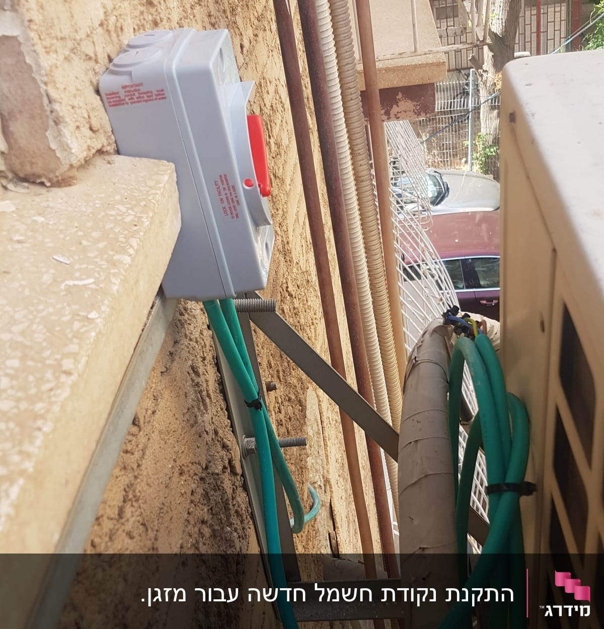 מתג חשמלי מותקן על קיר עם כבלים ירוקים